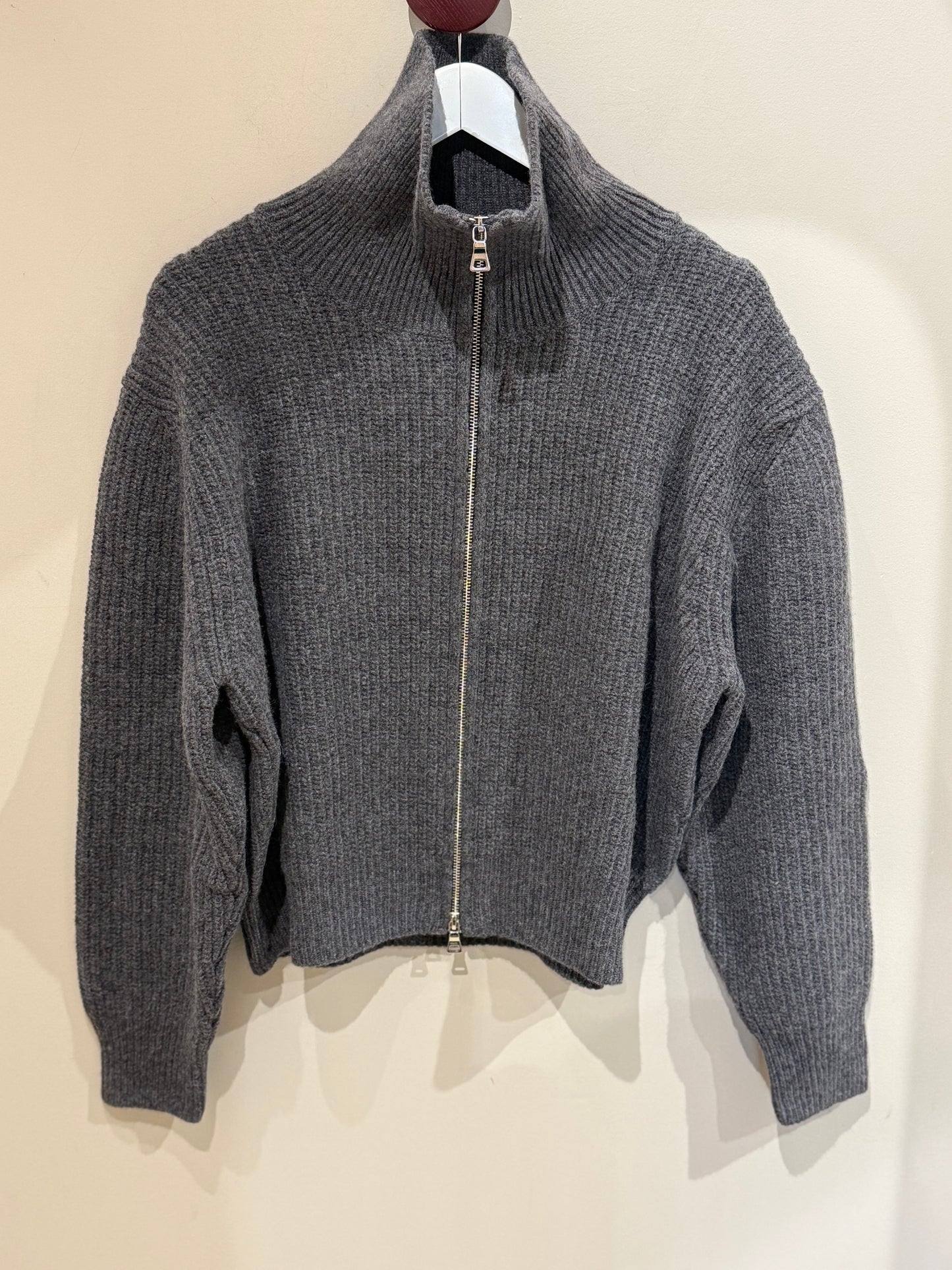 Trojer Jacke vor einer Wand fotografiert.