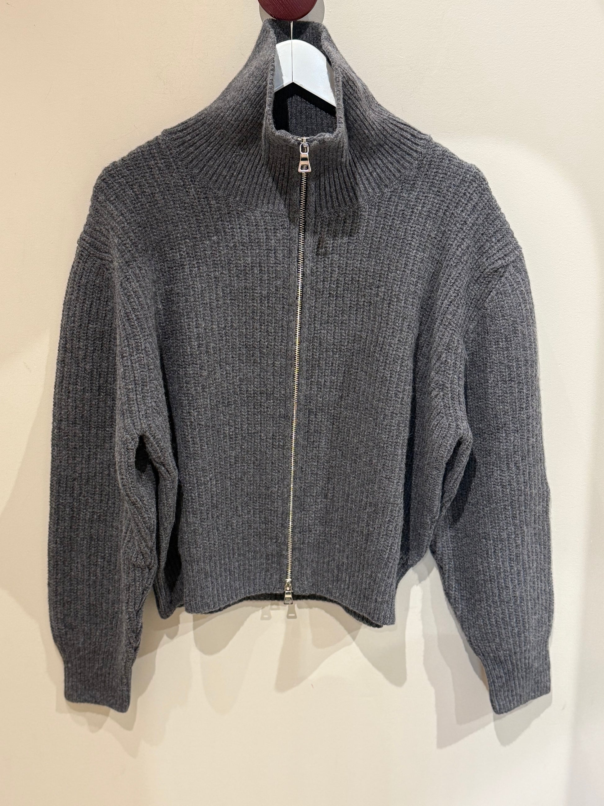 Trojer Jacke vor einer Wand fotografiert.