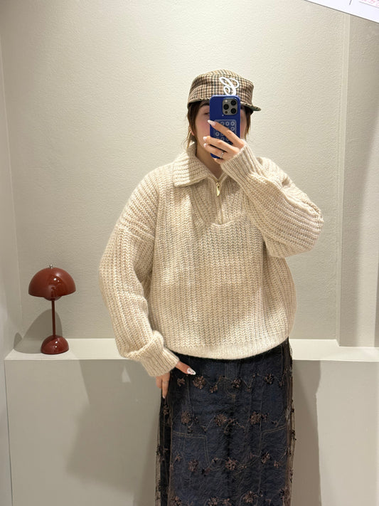 Frau macht Spiegelselfie sie trägt einen beigen Strick und dazu Jeans mit Spitzenrock darüber. Der Strick ist kastig geschnitten und hat einen Quarterzip.