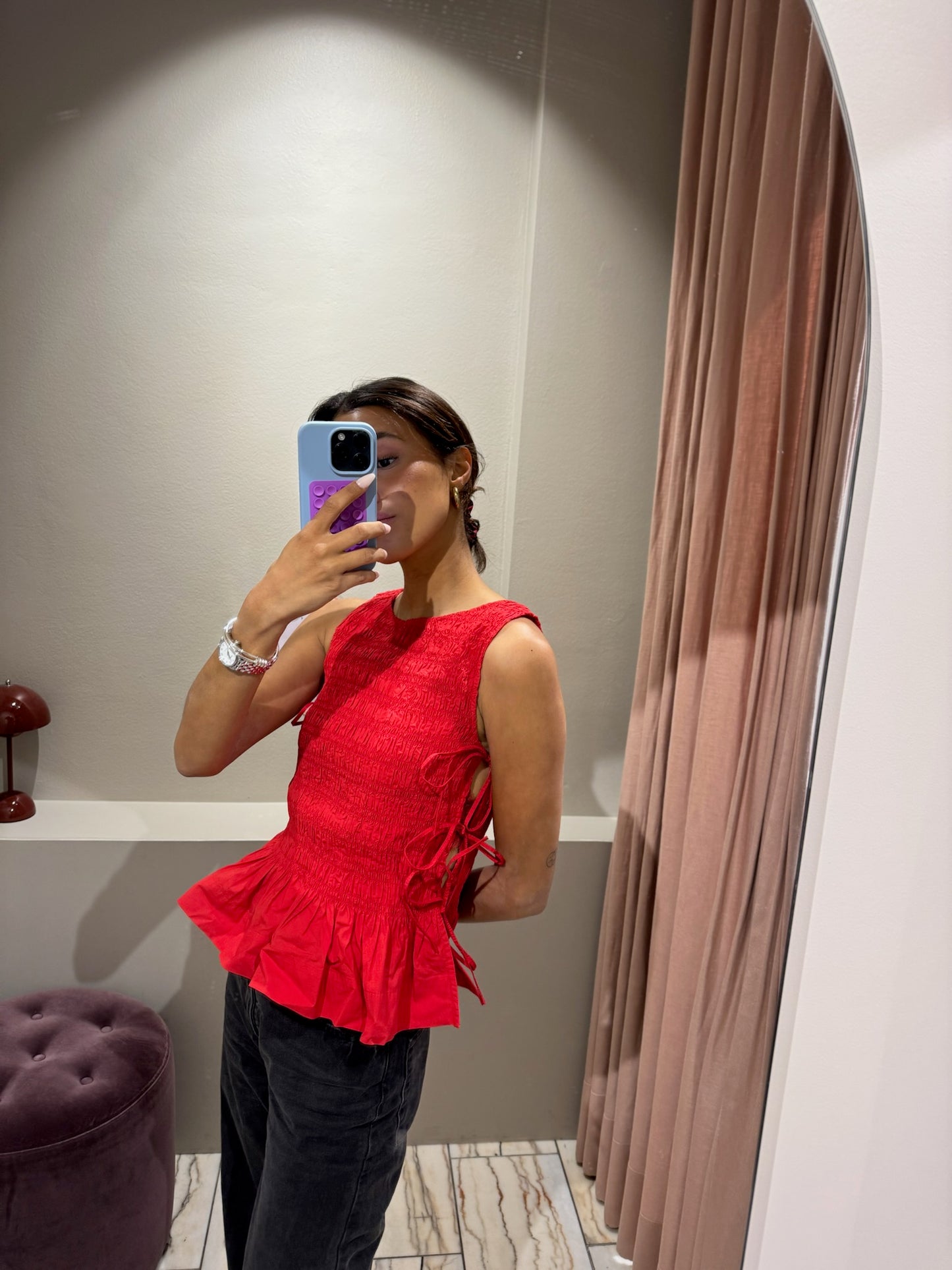 Gesmockte Bluse ohne Ärmel mit Peplum und Bindedetails. 