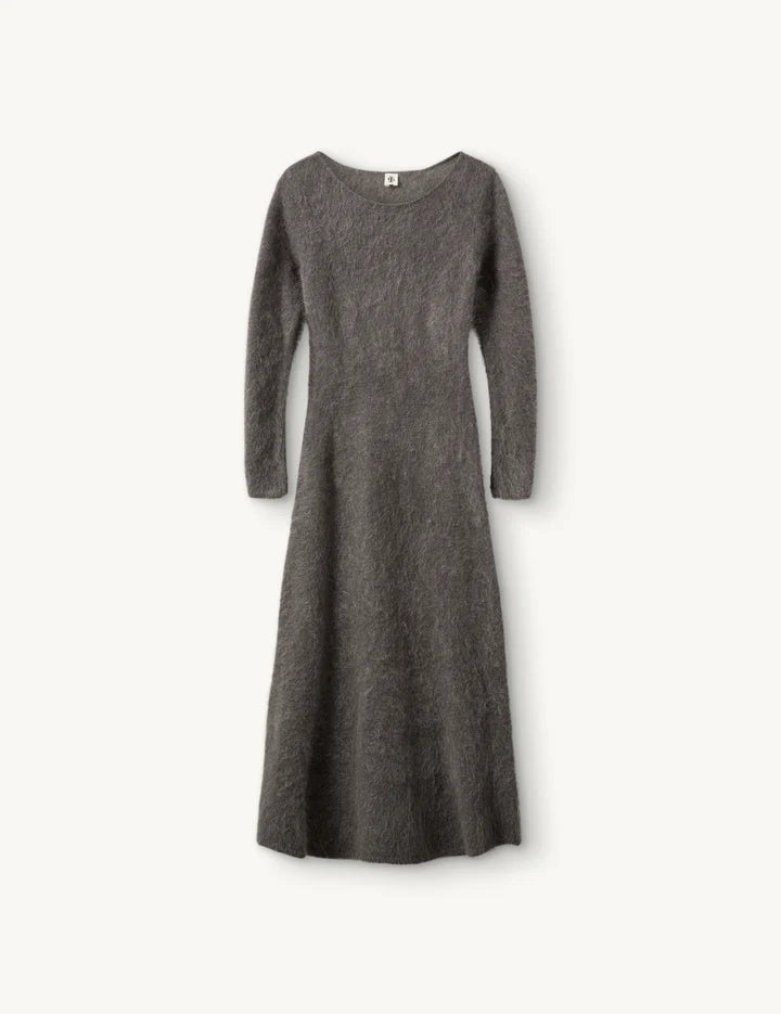 Graues Strickkleid aus Mohair mit tailiertem Schniktt vor weißem Hintergrund.