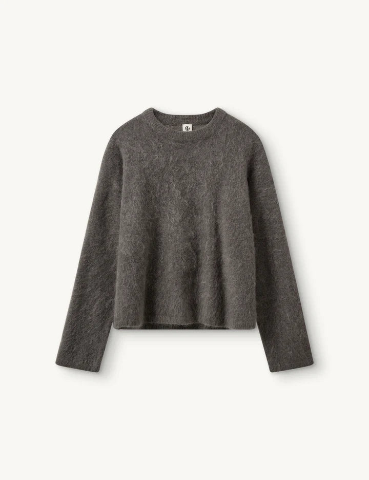 Grauer kastiger Mohair Sweater vor weißem Hintergrund.