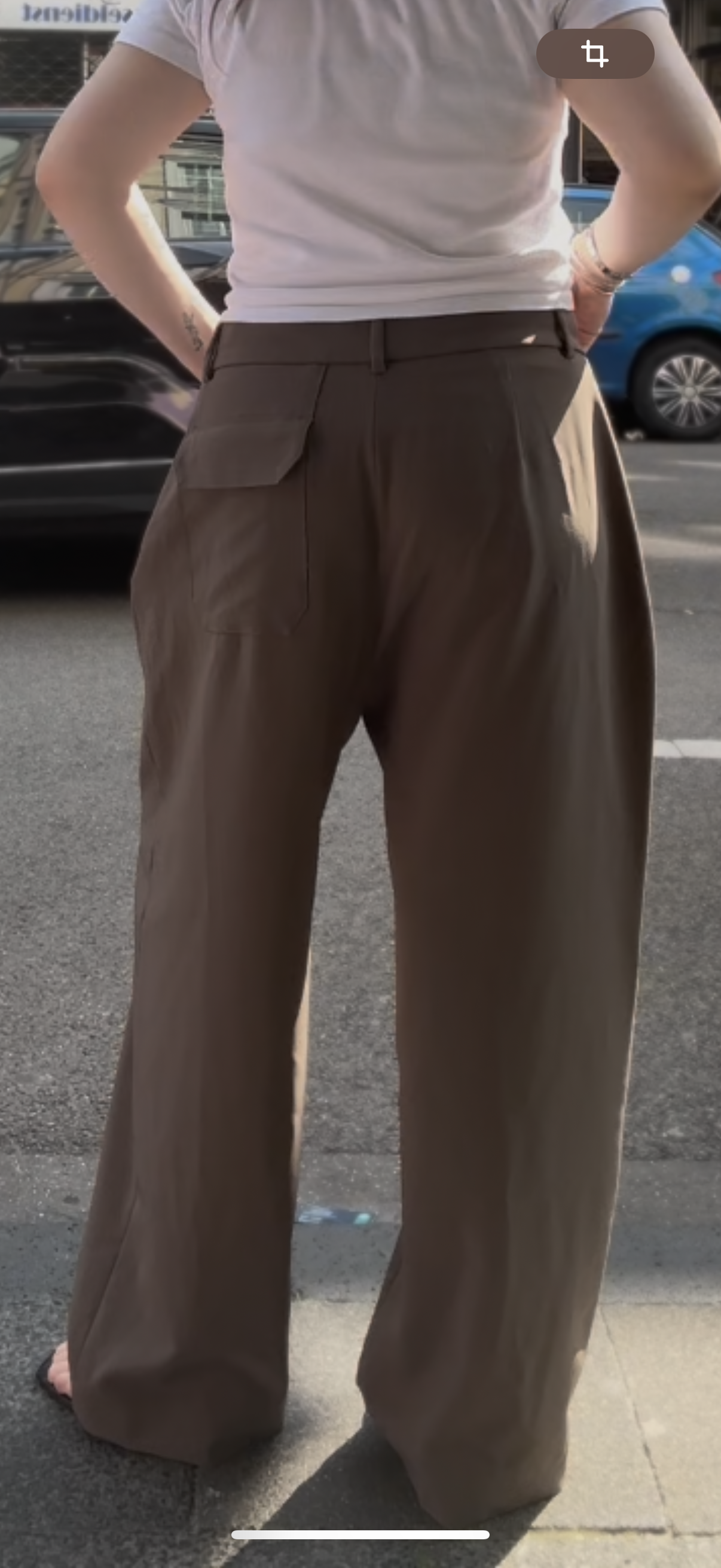 Frau von hinten, man sieht vor allem die Hose. Die Hose hat hinten rechts eine aufgesetze Tasche.