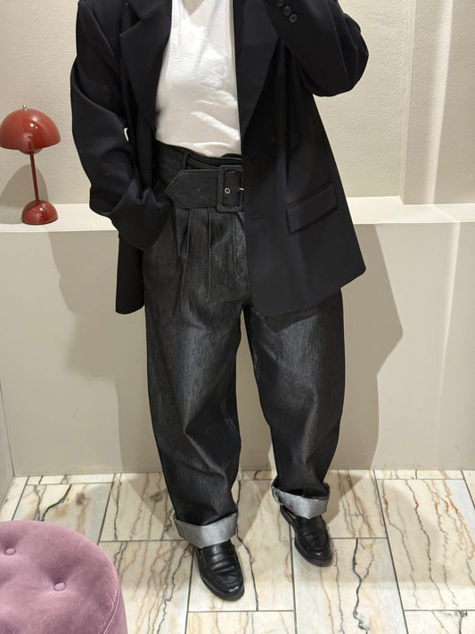 Frau mit Karottenjeans, Tshirt und Blazer in Umkleide.