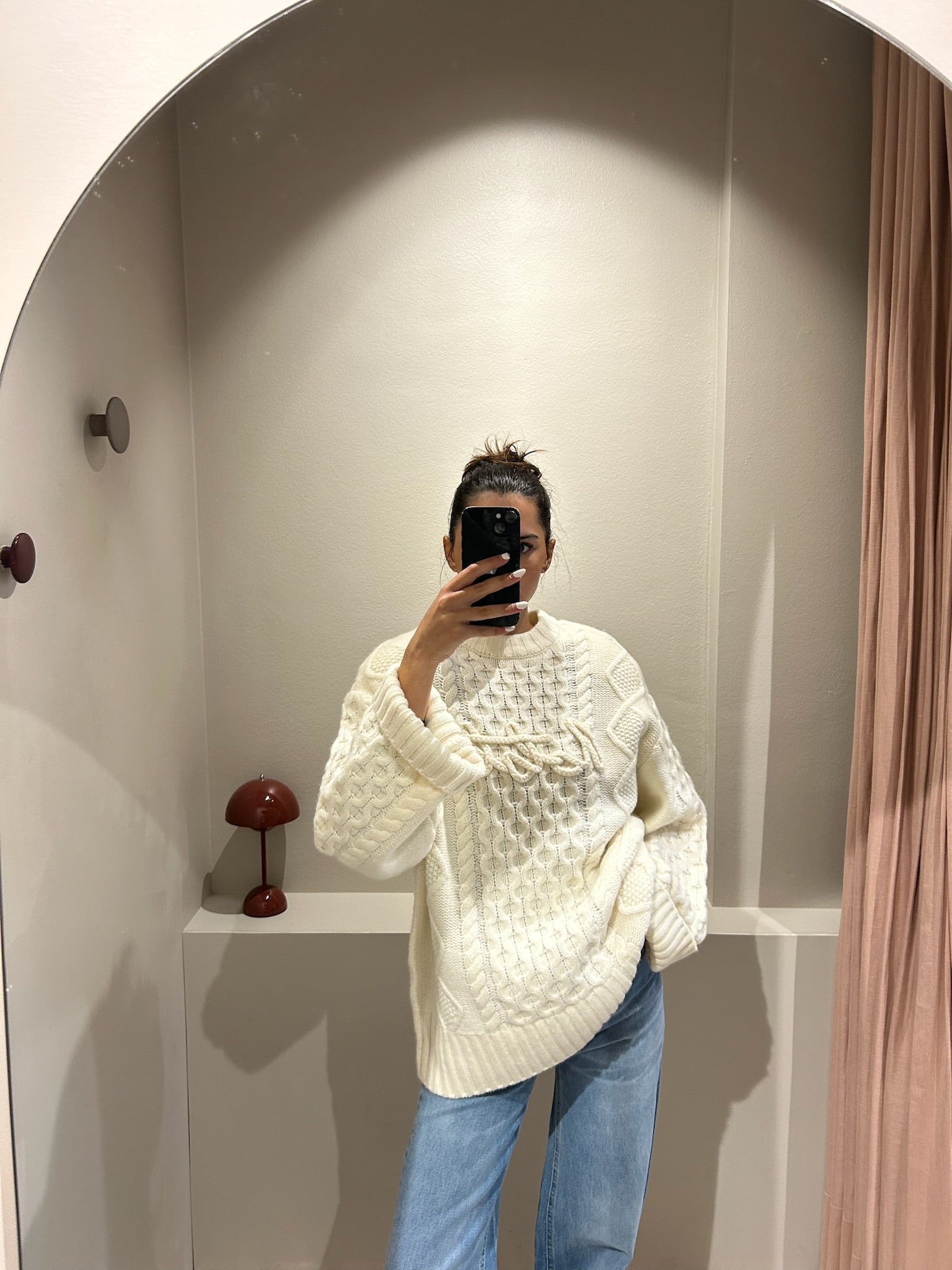 rau macht Speigelselfie, sie trägt einen kastigem weißen Cable Knit Sweater und Jeans.