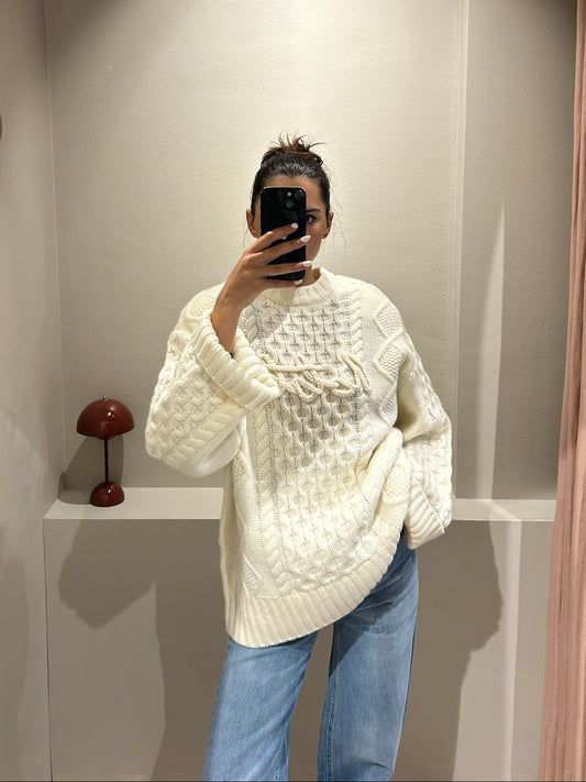 Fau macht Speigelselfie, sie trägt einen kastigem weißen Cable Knit Sweater und Jeans.