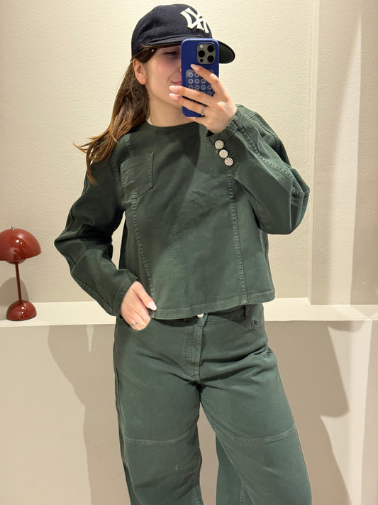 Frau macht Spiegelselfie in grünem Jenas Outfit bestehend aus Bluse und weiter Jeans.