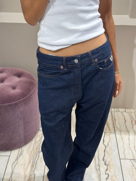 Frau im Spiegel, sie trägt eine dunkleblaue lässige Jeans und ein weißes Top.